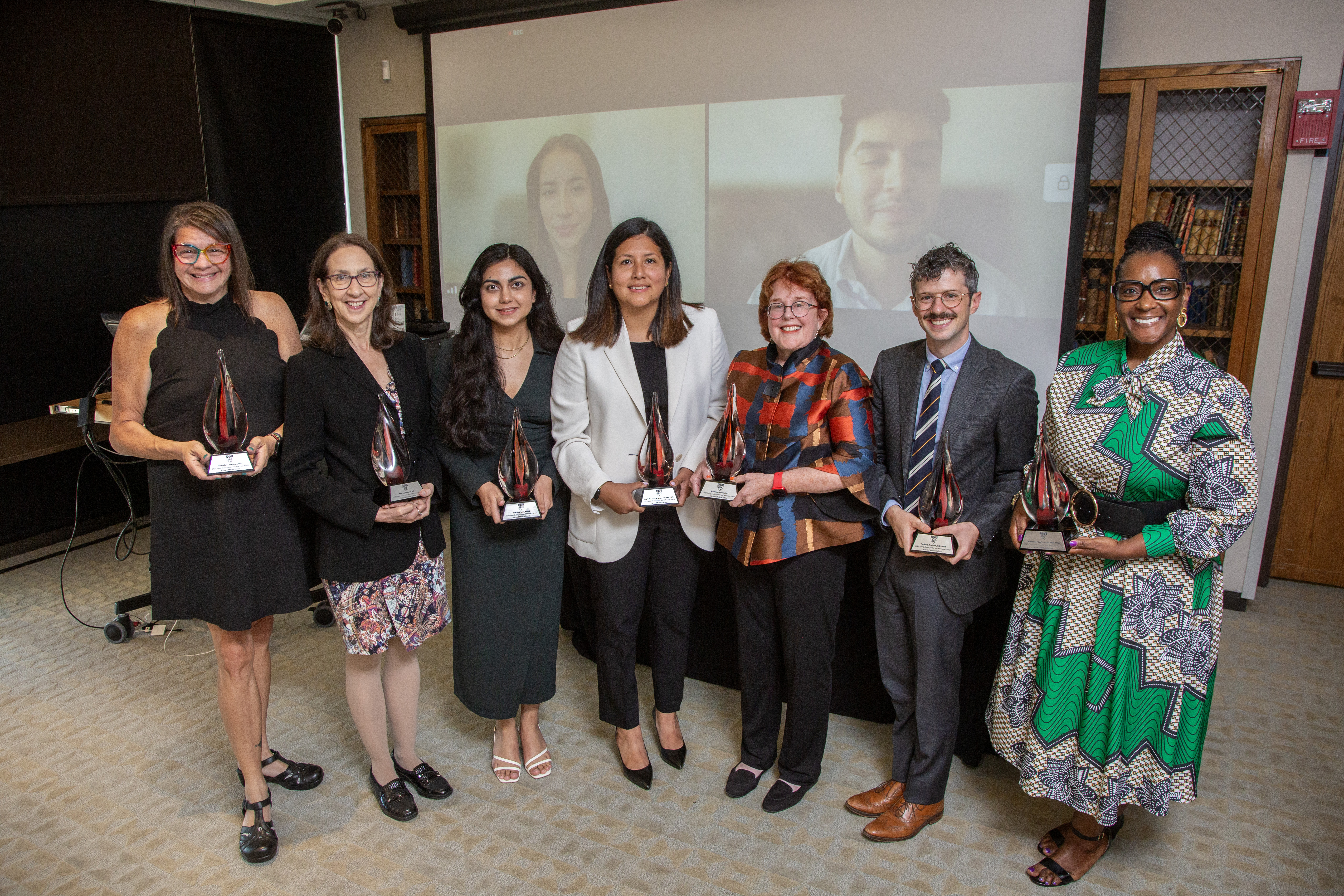 The 2023 ESJA awardees line up for a photo, with some recipients joining in virtually behind them. 